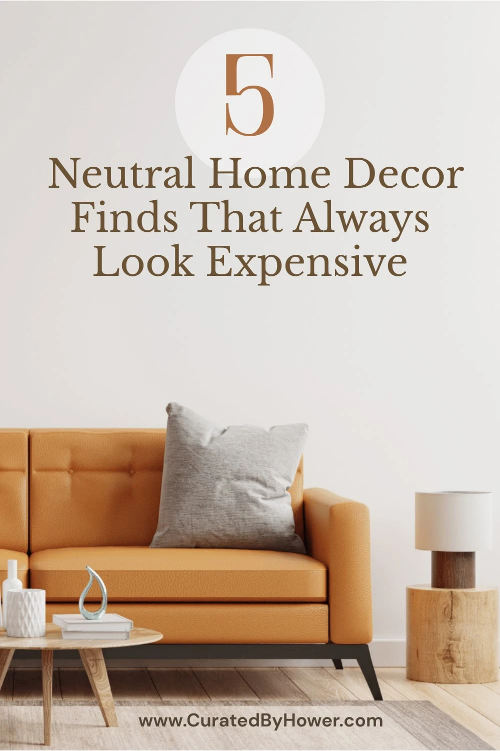 Tan leather sofa with white pillow in modern living room with neutral decor and wooden side table