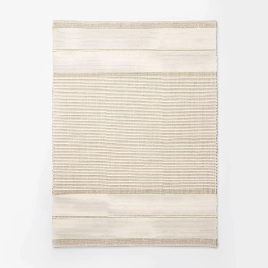 Neutral striped area rug with beige and cream horizontal bands in minimalist design for living room decor