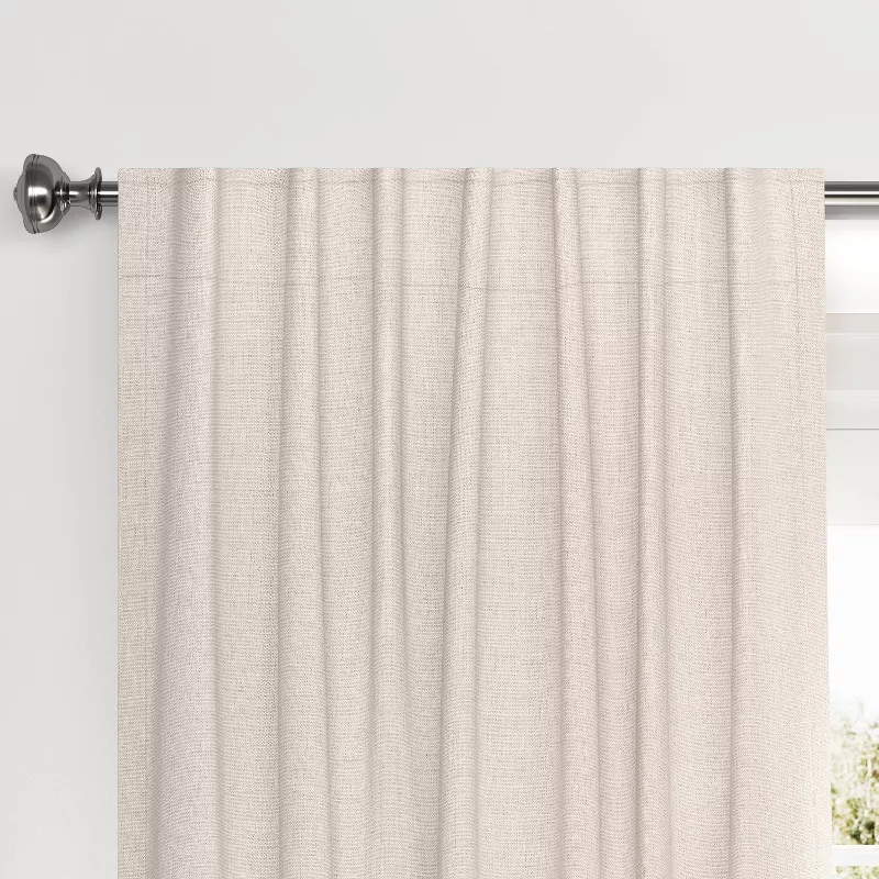 Cream blackout velvet curtain panel hanging on silver curtain rod with natural light filtering through
