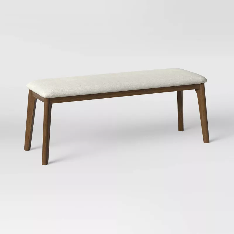 Mid-century modern upholstered dining bench with wooden legs and cream cushioned seat from Target