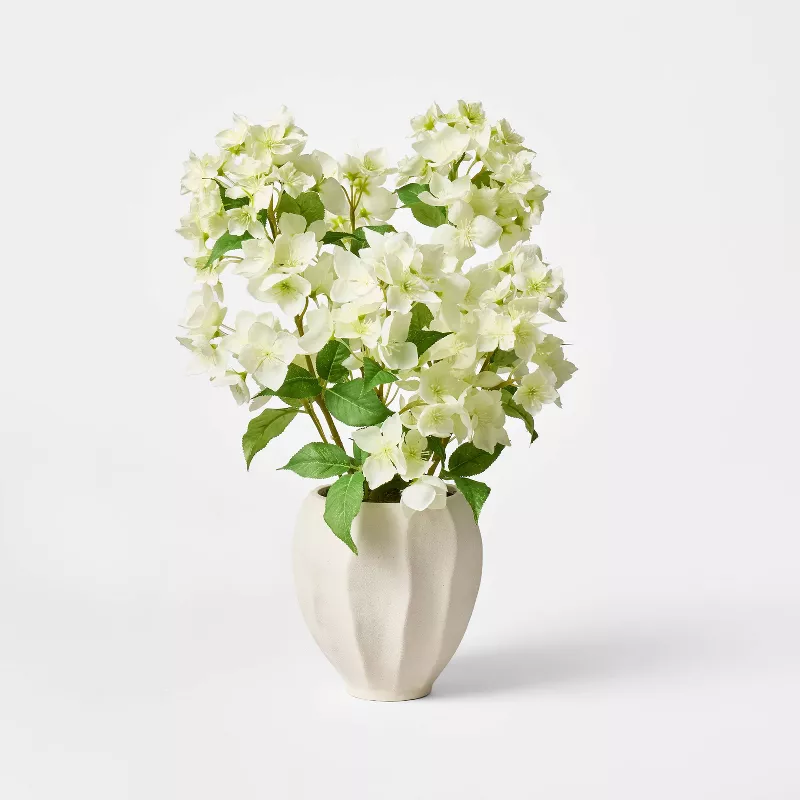 White faux hydrangea flowers in modern geometric ceramic vase from Target