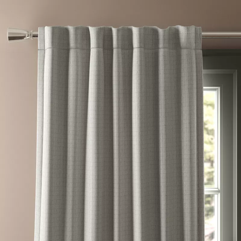 Gray blackout textured plaid curtain panel hanging on rod with back tab header and light blocking fabric