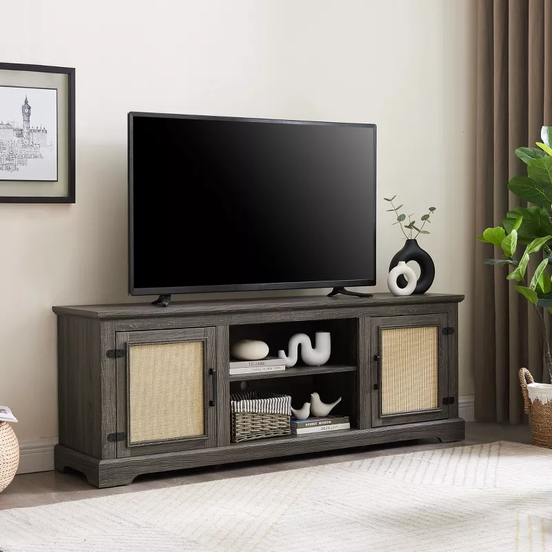 Gray wooden TV stand with cane doors and open shelving displaying decor beneath flat screen television
