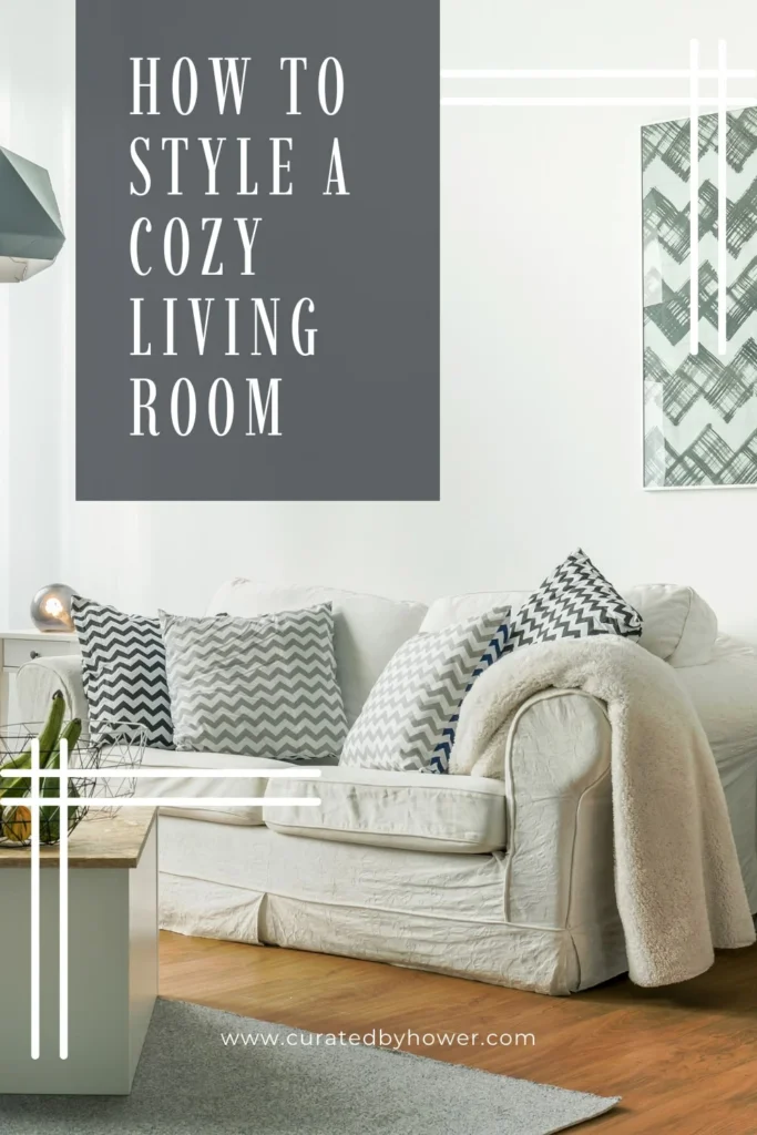 Cozy white sofa with gray patterned pillows and cream throw blanket in bright living room with modern decor