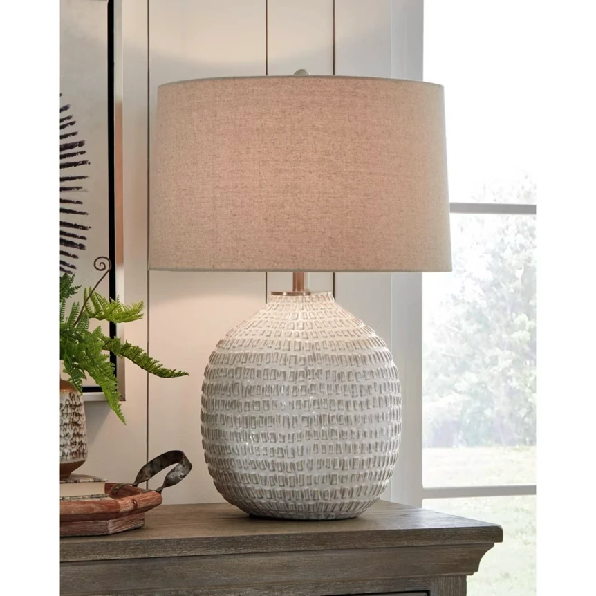 Textured ceramic table lamp with linen shade on a console table