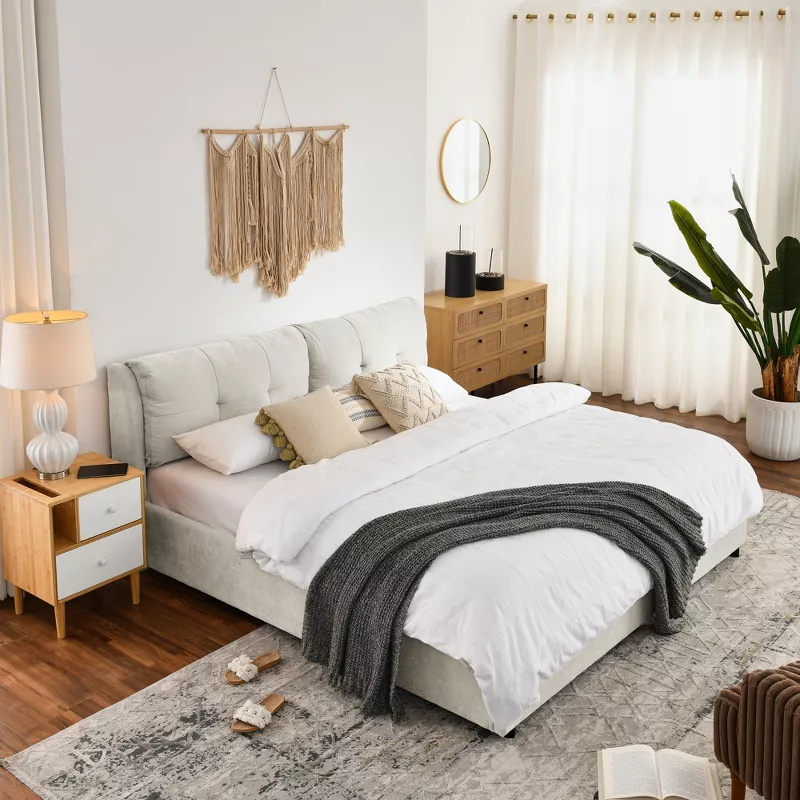 Modern white upholstered storage bed with gray throw blanket in bright boho bedroom with wooden furniture