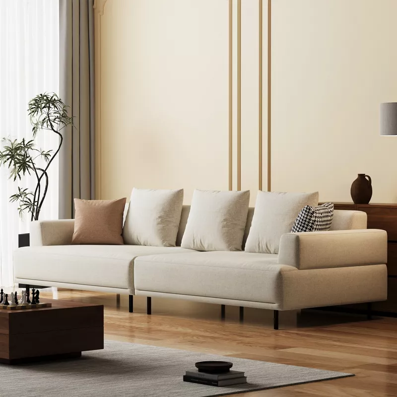 Modern beige sectional sofa with decorative pillows in minimalist living room with wood flooring and neutral decor