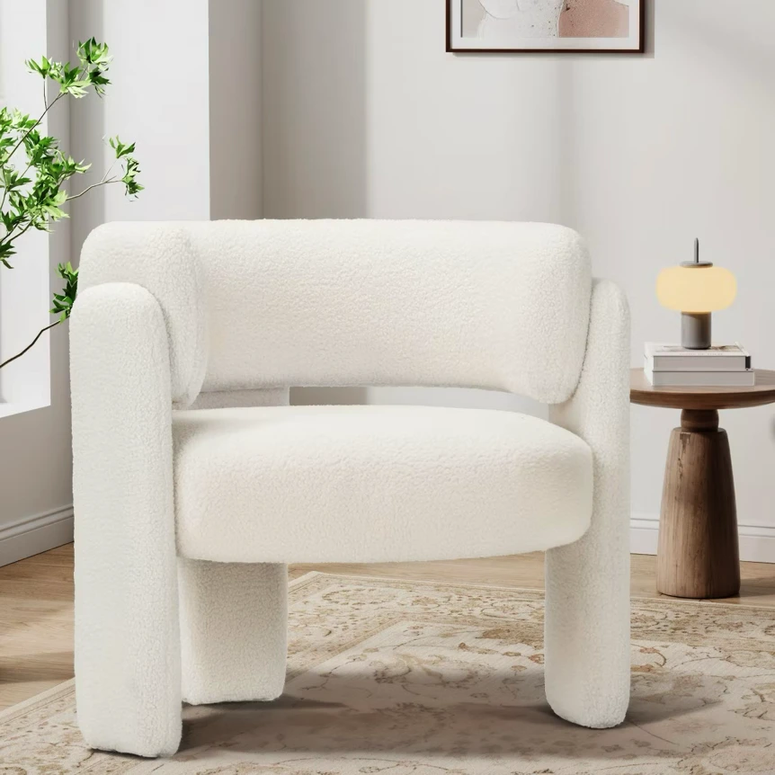 Modern cream upholstered accent chair with curved arms in minimalist living room with plants and side table