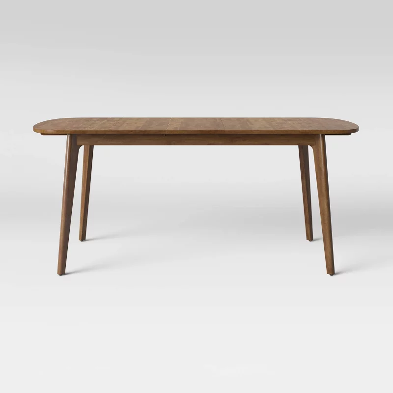 Modern wooden dining table with tapered legs and oval top in natural walnut finish