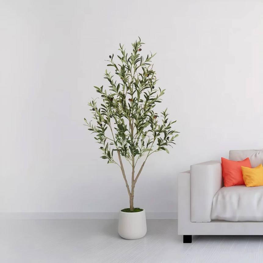 Faux olive tree in white pot next to modern sofa with colorful pillows in minimalist living room