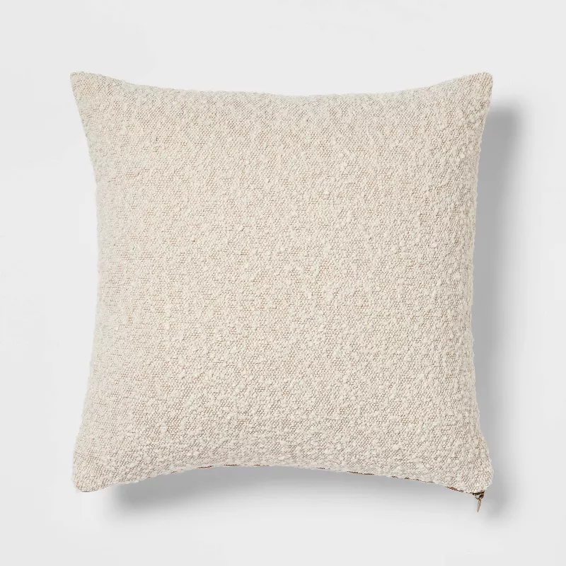 Cream boucle textured square throw pillow with soft woven fabric finish on white background