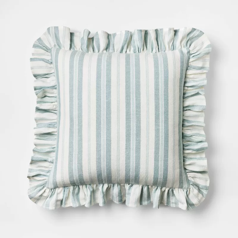Blue and white striped throw pillow with ruffled edges on white background
