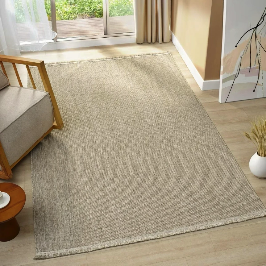 Neutral beige area rug in modern bedroom with wooden furniture and natural light from window