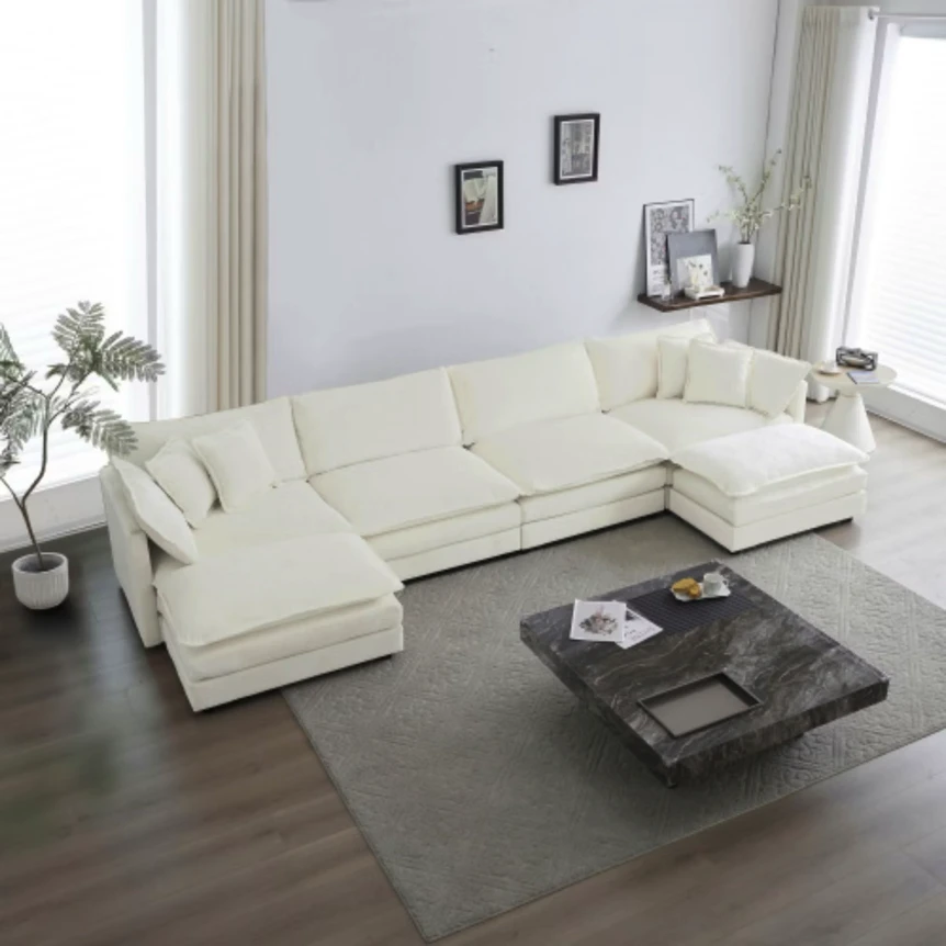 Large white U-shaped sectional sofa with chaise in modern living room with dark wood floors and gray coffee table