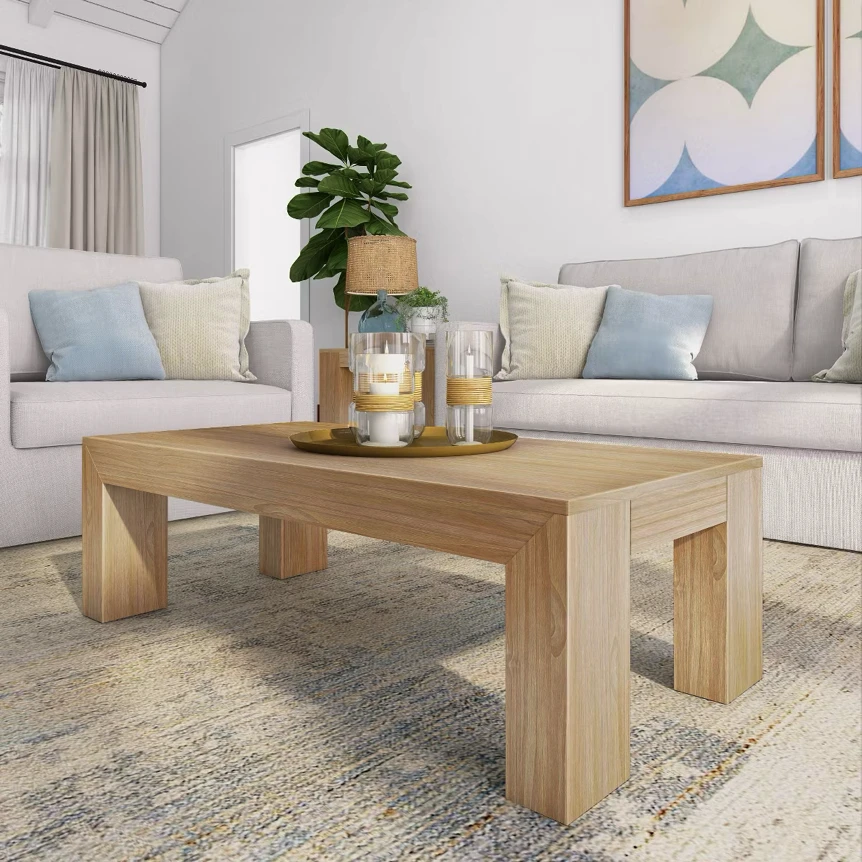 Modern wooden coffee table with chunky legs on area rug between white sofas in neutral living room