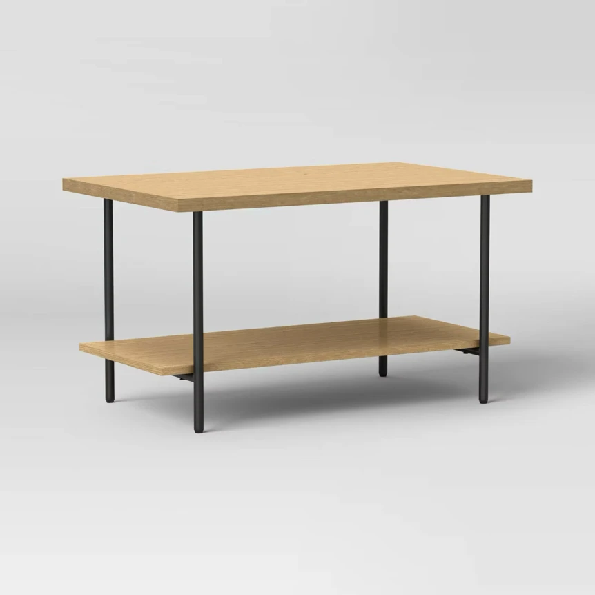 Wood and metal coffee table with natural finish and lower storage shelf on light background