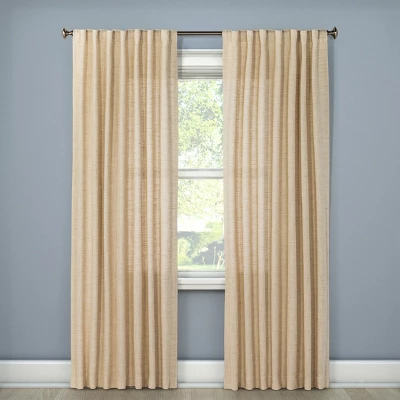 Light filtering cream textured weave curtain panels hanging on rod beside window with blue-gray walls