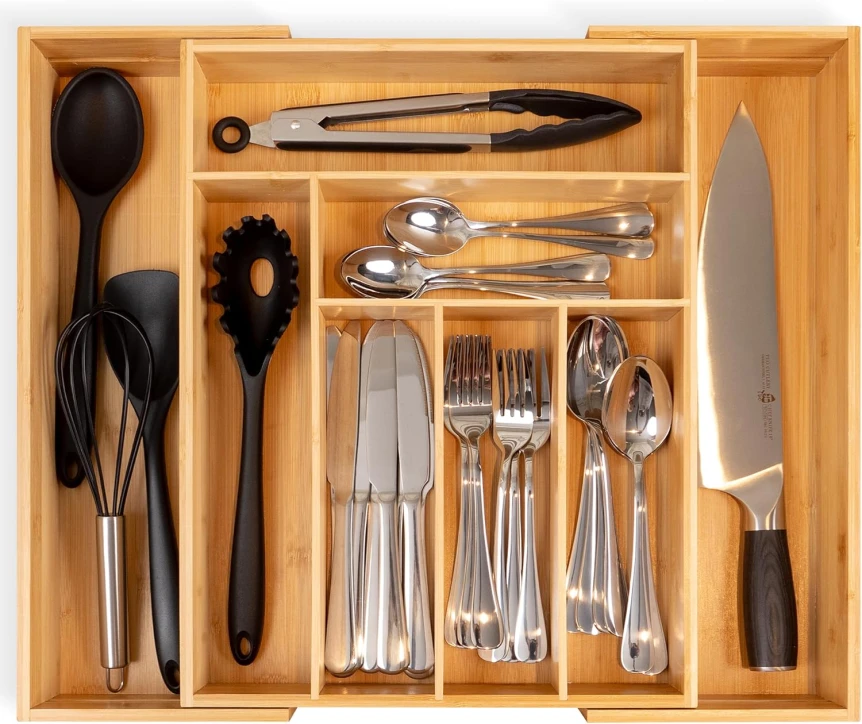Organized kitchen drawer with bamboo dividers holding utensils, silverware, and cooking tools neatly separated
