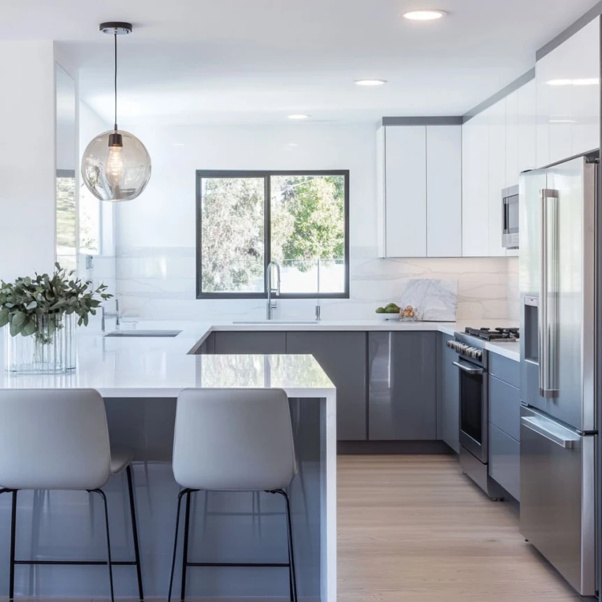 A modern kitchen embodies a sleek modern design where sharp contrasts between glossy white upper cabinetry and deep grey lower cabinets