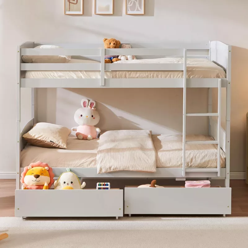 White twin-over-twin bunk bed with storage drawers and ladder, decorated with stuffed animals and neutral bedding