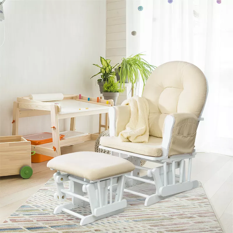 White glider chair with ottoman in bright nursery room with plants and natural wood furniture