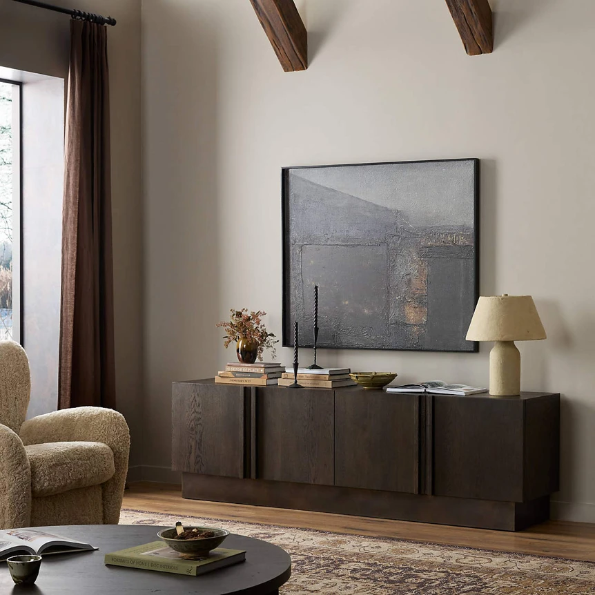 Modern dark wood TV stand with abstract artwork table lamp and decorative items in contemporary living room