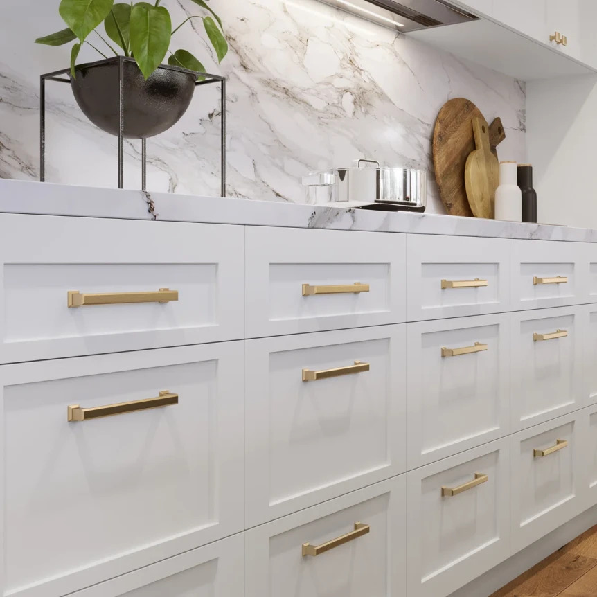 close-up of shaker kitchen cabinets in warm white with brushed brass hardware