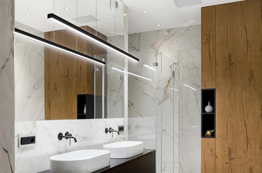 Modern bathroom with linear LED lights, marble walls, wooden accents, dual vessel sinks, and glass shower enclosure