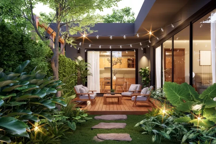 Modern patio with string lights, wooden deck, contemporary furniture, and lush tropical plants at dusk