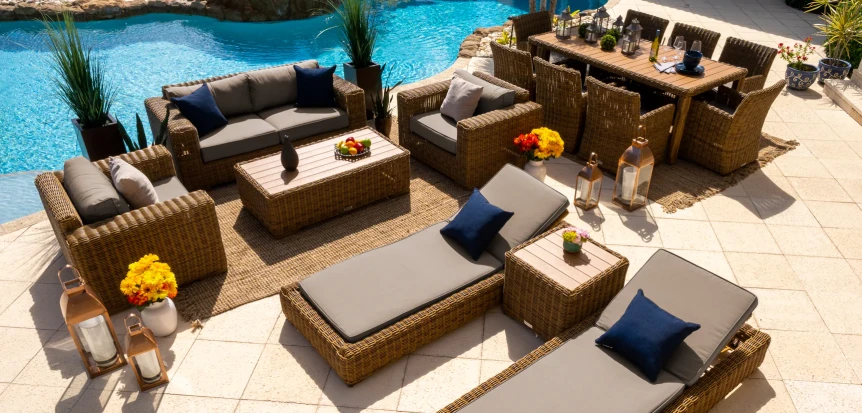 Luxury poolside patio with wicker furniture, dining set, and lounge chairs overlooking turquoise swimming pool