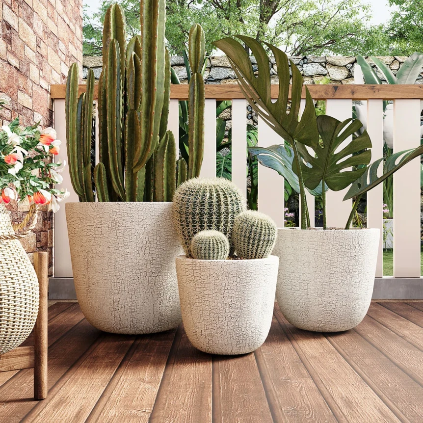 Textured beige planters with cacti and tropical plants arranged on wooden deck patio with white railing
