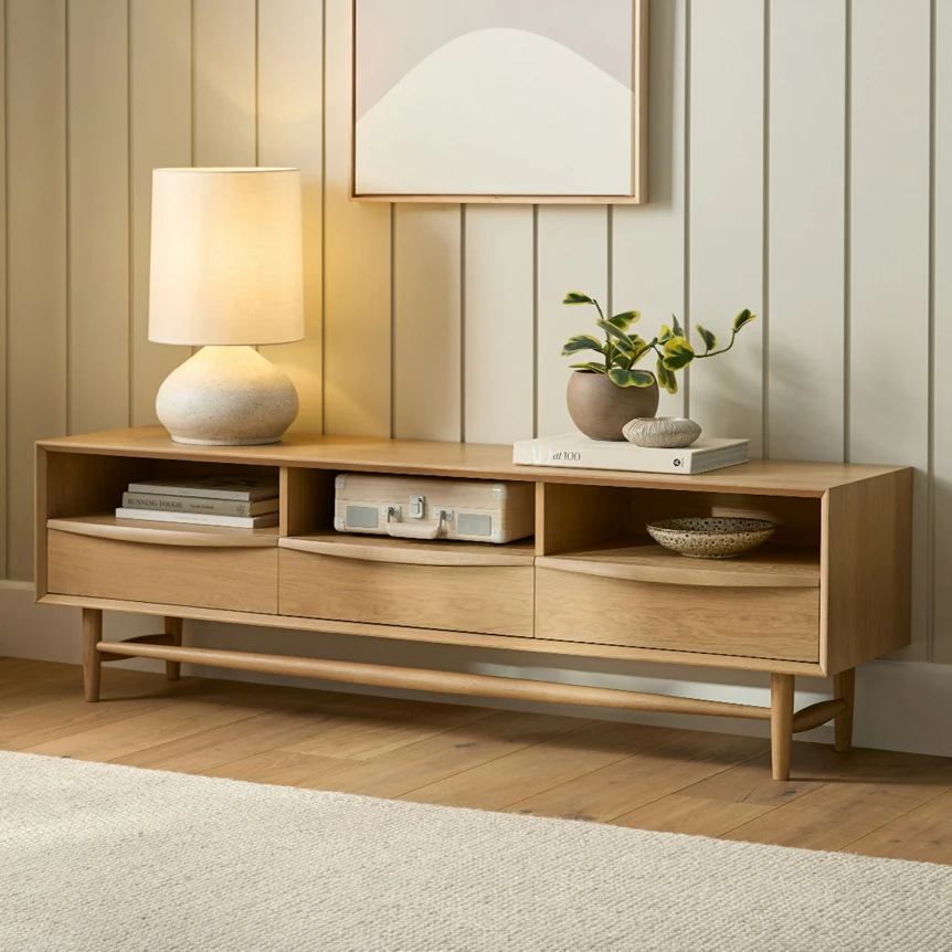 Modern wooden TV stand with open shelving and drawers on metal legs in contemporary living room setting