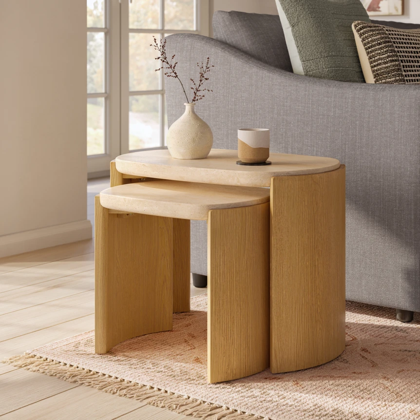 Modern nesting side tables in natural wood finish with curved cylindrical design in contemporary living room setting