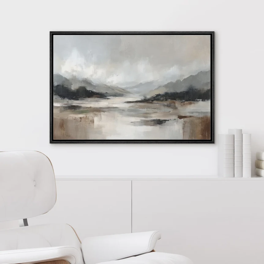 Abstract landscape painting with gray clouds and beige tones in black frame above white cabinet in minimalist living room