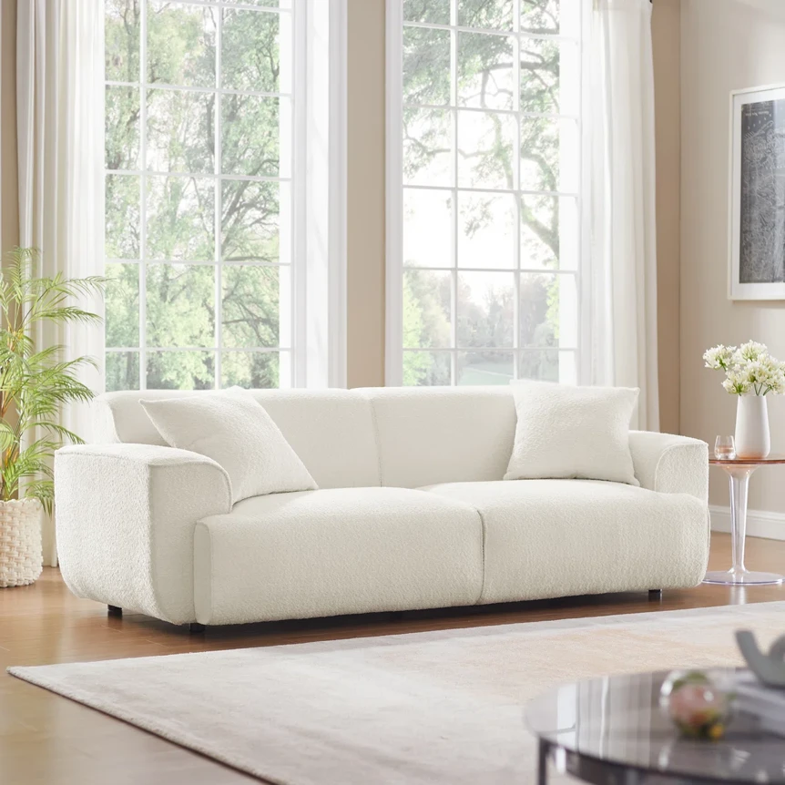 White modern sofa with clean lines in bright living room with large windows and minimalist decor
