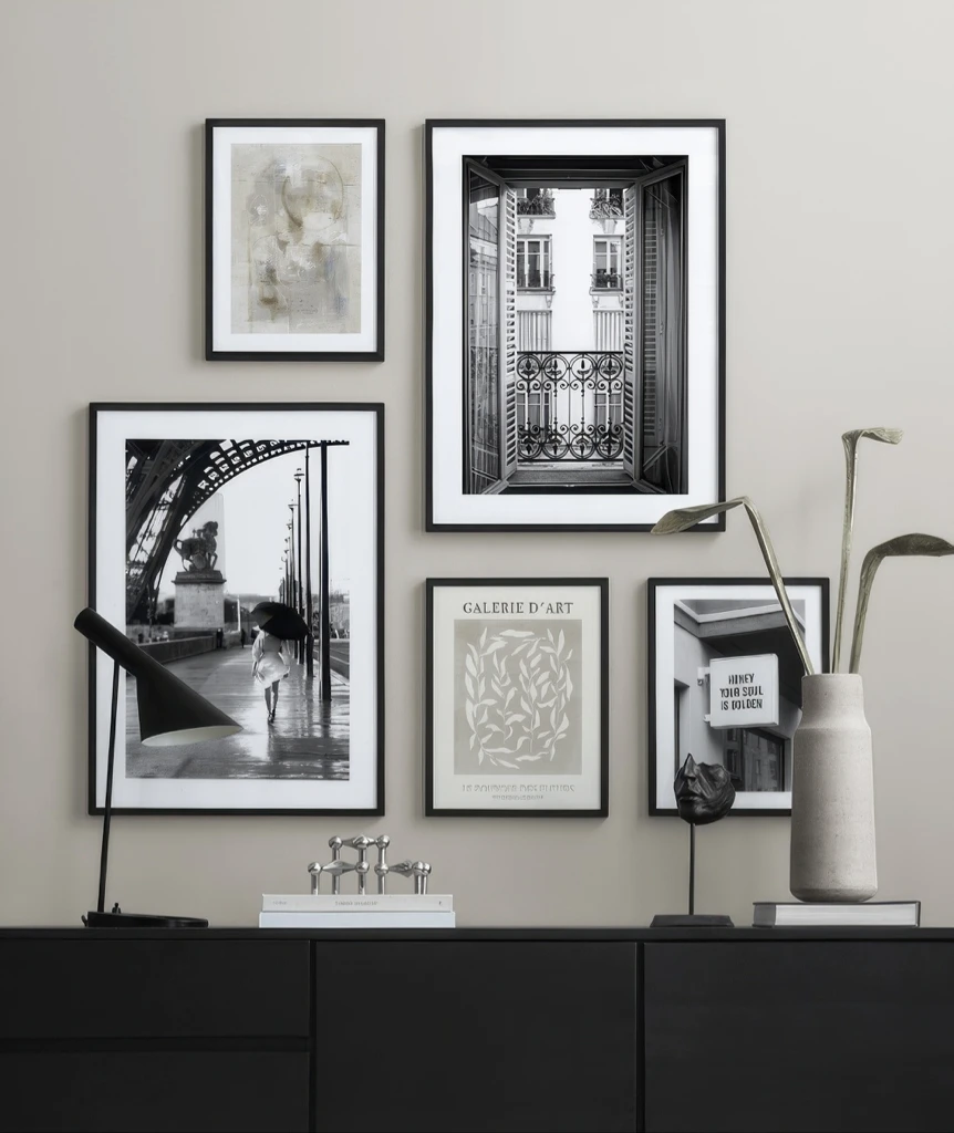 Gallery wall with black framed photography prints above modern black console table with minimalist decor
