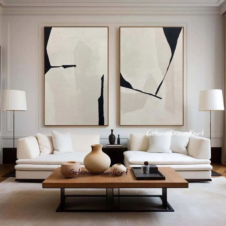 Modern living room with abstract geometric wall art, white sofa, and minimalist coffee table in neutral tones