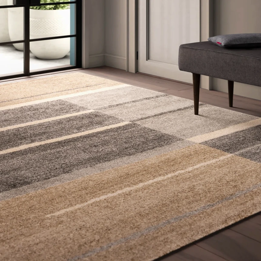 Modern striped area rug in neutral beige and brown tones on hardwood floor with furniture in contemporary living room