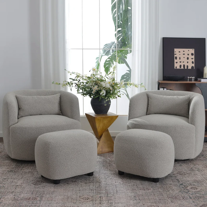 Modern living room with curved gray chairs, matching ottomans, and wooden accent table with plant centerpiece