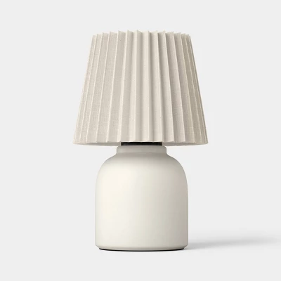 Mini ceramic ivory table lamp with pleated fabric shade on white background