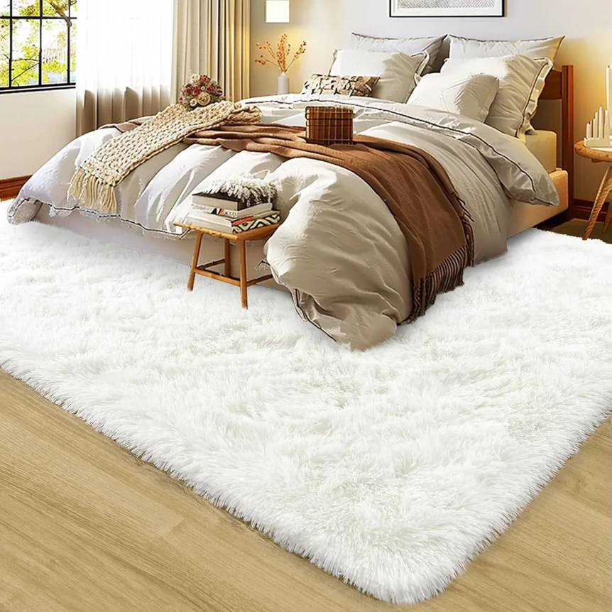 White fluffy shag rug under bed in cozy bedroom with neutral bedding and wooden floor
