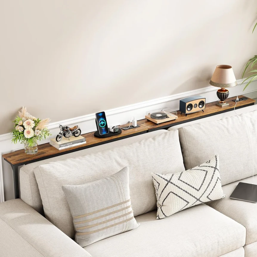 Long wooden console table behind cream sofa with decorative pillows and home decor accessories in cozy living room