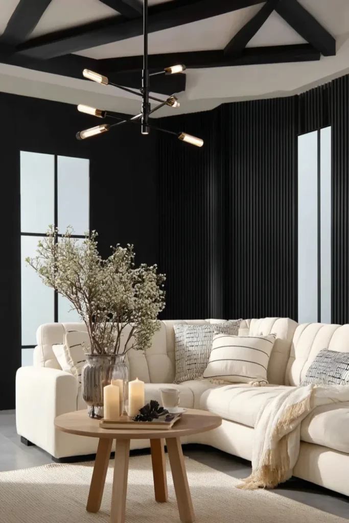 Scandinavian living room with black wall accent, layered lighting, and candle vignettes