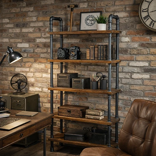 Industrial pipe bookshelf with wooden shelves against exposed brick wall in rustic home office with leather chair