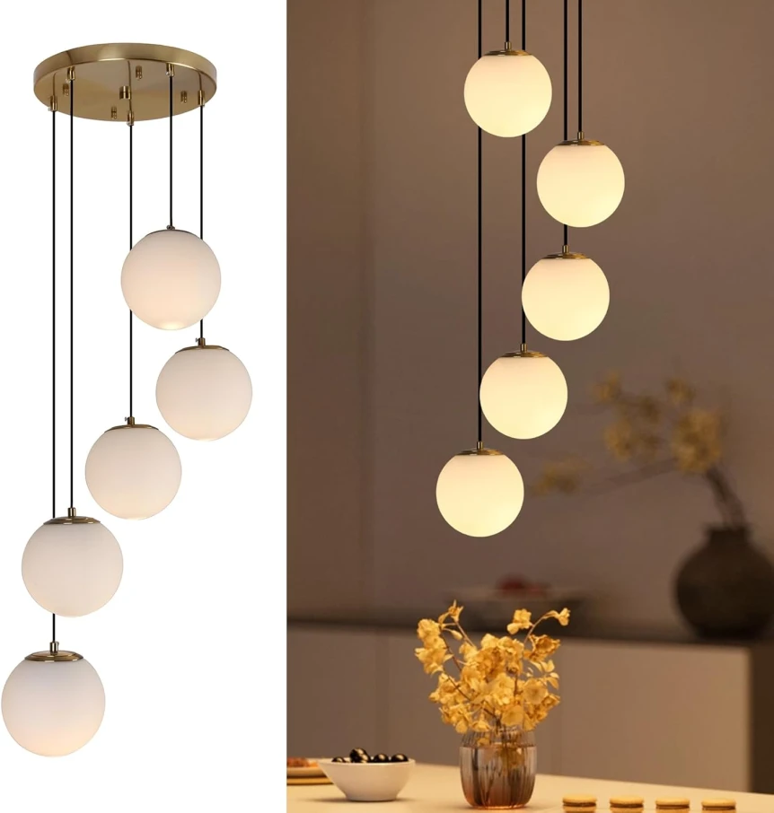 Mid-century modern pendant chandelier with cascading white glass globe lights on brass fixture over dining table
