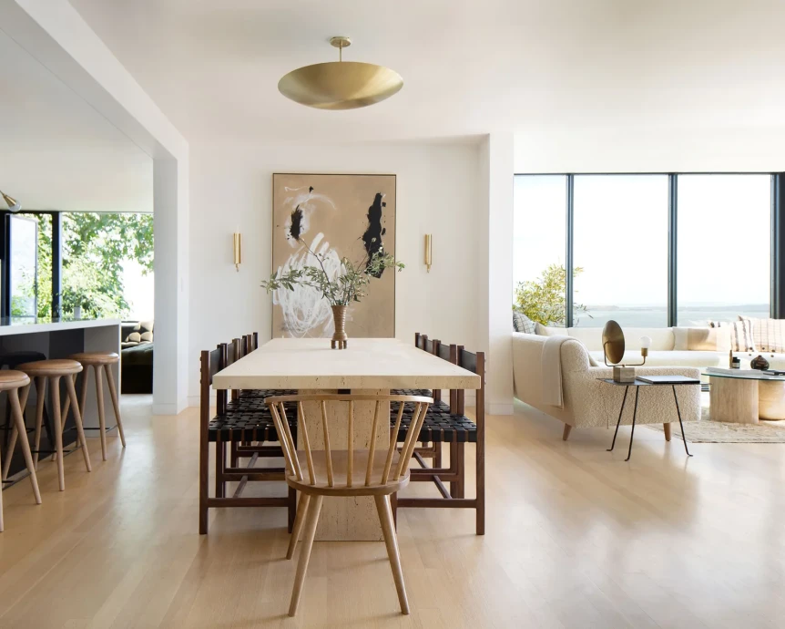 Modern Scandinavian dining room with light wood floors, minimal furniture, and large windows with natural light