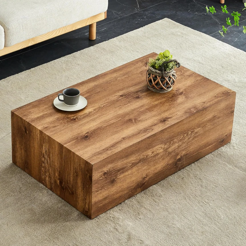 Rustic wooden block coffee table with coffee cup and plant on light gray rug in modern living room