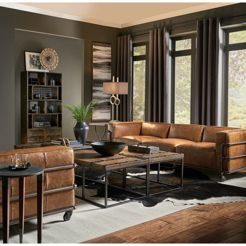 Industrial living room with brown leather sofa, metal coffee table, and dark wood furniture featuring vintage design