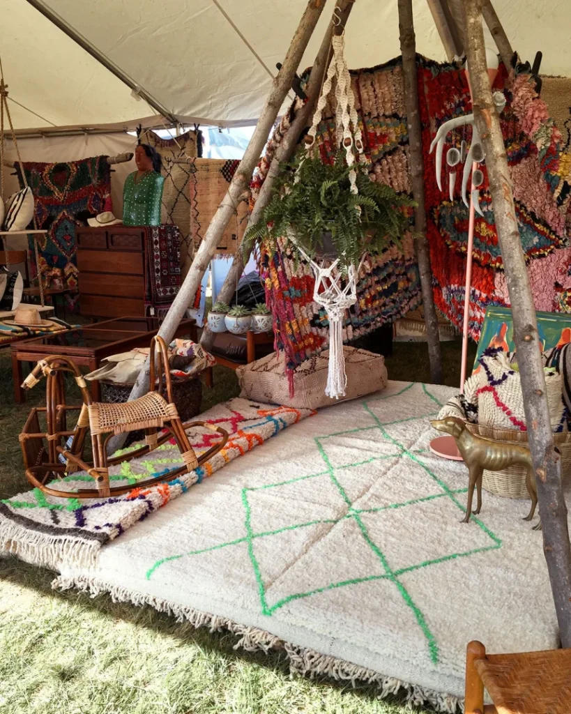 Bohemian-style tent interior with colorful rugs, tapestries, dreamcatchers, and eclectic decorations creating cozy atmosphere