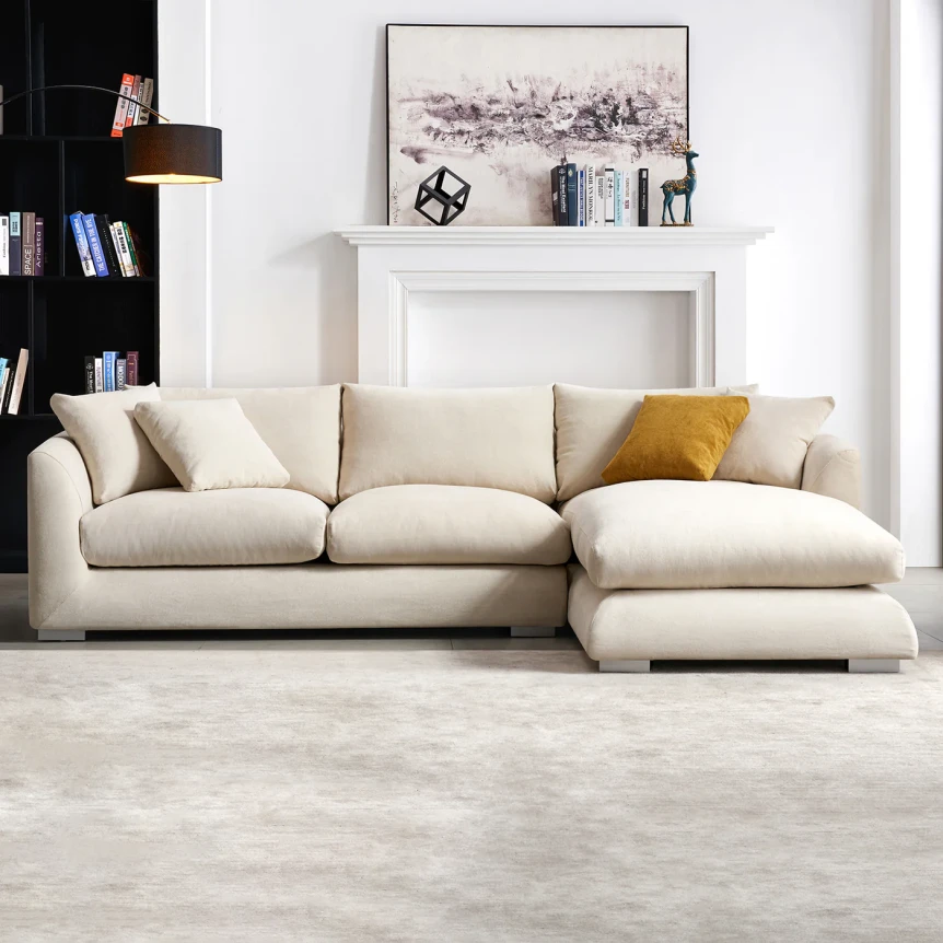 Cream sectional sofa with chaise lounge in modern living room with white fireplace and neutral decor